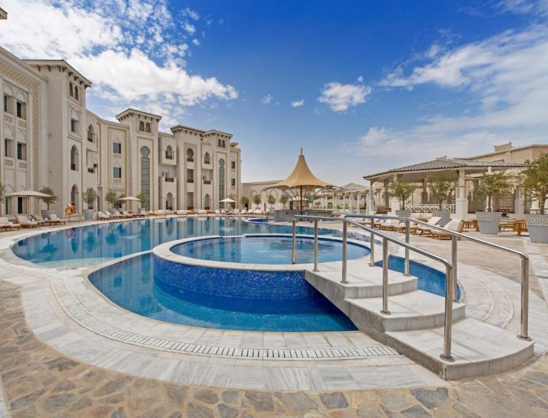 Piscina exterior con jacuzzi y arquitectura árabe del Ezdan Palace Hotel en Qatar