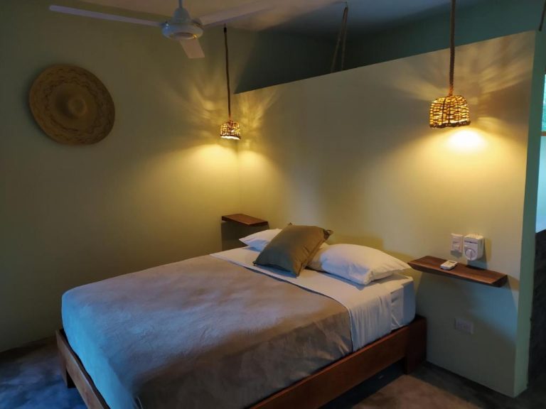 Habitación doble acogedora con lámparas de mimbre y ventilador de techo en Residencia El Balatà