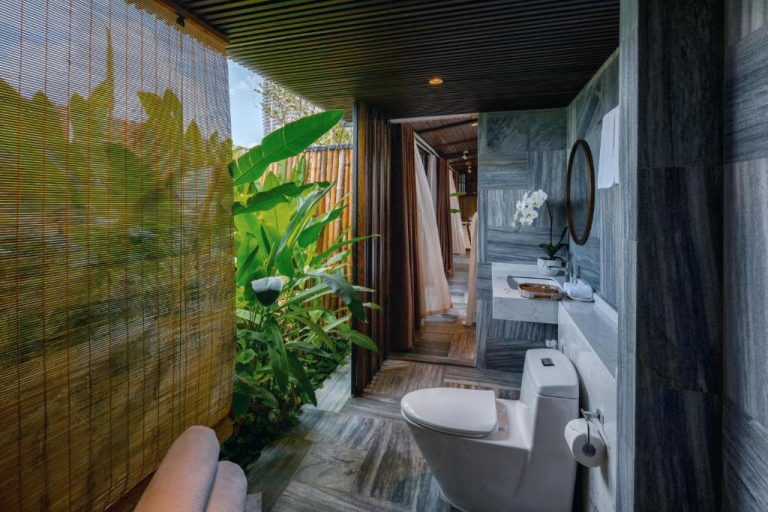 Baño de lujo con jardín tropical y paredes de mármol gris en el Minh Boutique Hotel