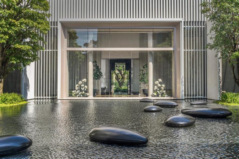 Entrada principal del Four Seasons Bangkok con estanque decorativo y piedras negras en jardín zen