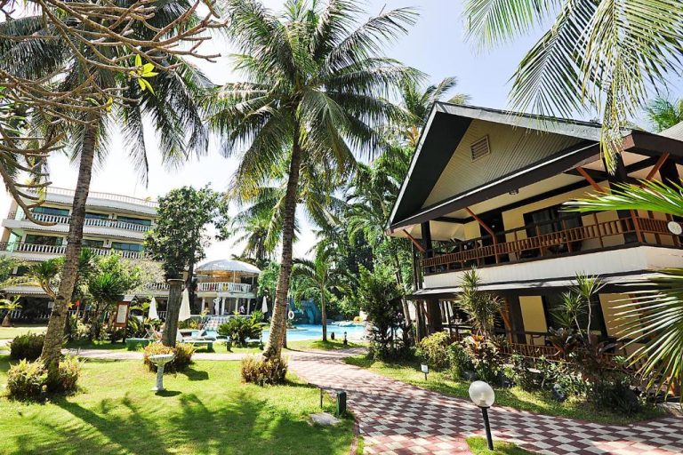 Jardines tropicales con palmeras y piscina exterior del Paradise Garden Hotel and Convention Center Boracay