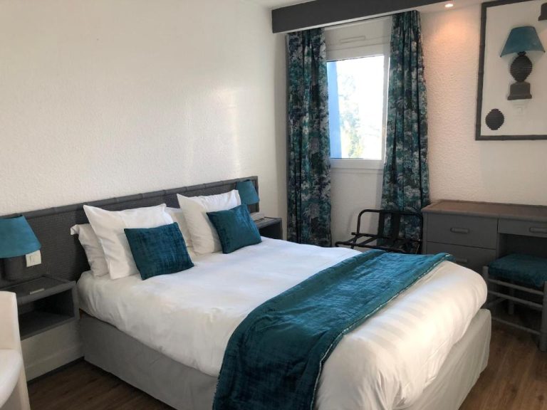 Habitación doble con cama king size y decoración en azul turquesa del Hotel Le Noirlac