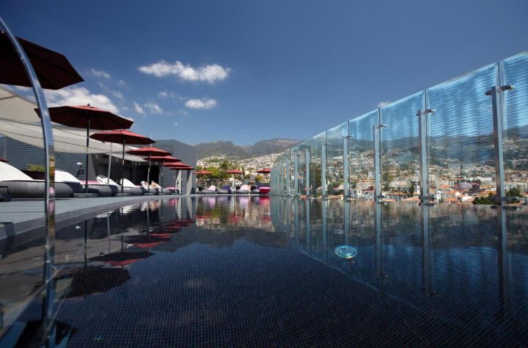 Piscina infinita con vistas panorámicas a Funchal y la montaña en The Vine Hotel Madeira
