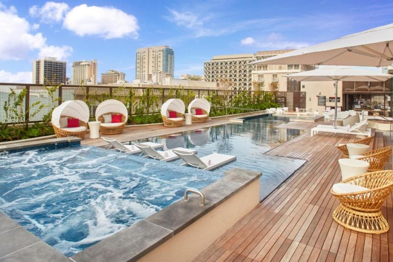 Piscina exterior con jacuzzi y tumbonas en la terraza del Hyatt Centric Waikiki Beach con vistas a la ciudad