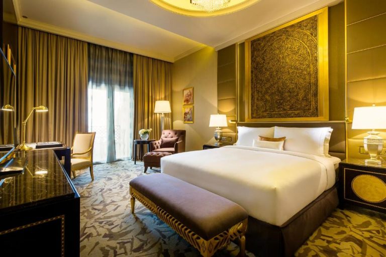 Lujosa habitación deluxe con decoración dorada y cama king size en Ezdan Palace Hotel Qatar