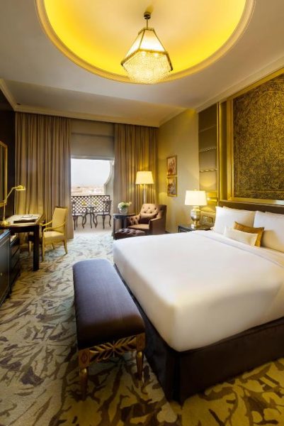 Habitación deluxe lujosa con cama king size y decoración dorada en Ezdan Palace Hotel Qatar