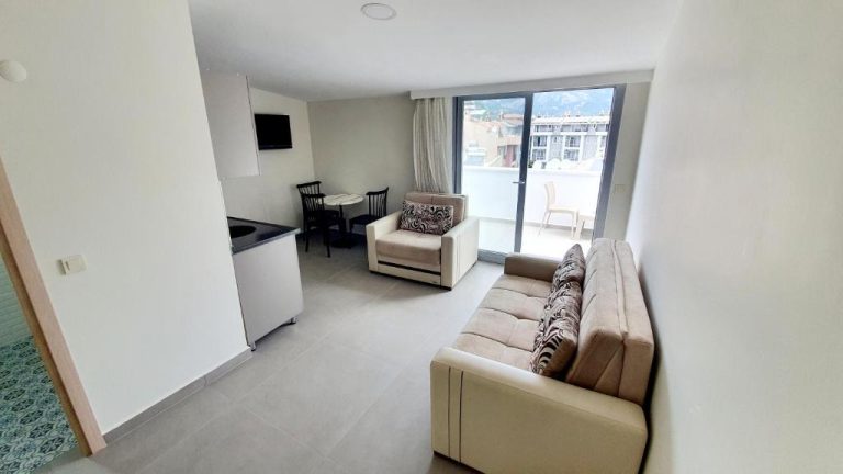 Salón con sofá, sillón y comedor con acceso a terraza en apartamento del Ressa Apart