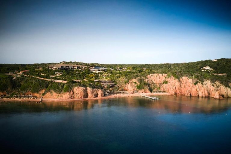 Vista aérea del Hotel U Capu Biancu con playa privada y acantilados rojos en Bonifacio, Córcega