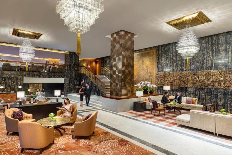 Elegante lobby del Mandarin Oriental Hong Kong con lujosas lámparas de cristal y sofisticada decoración oriental