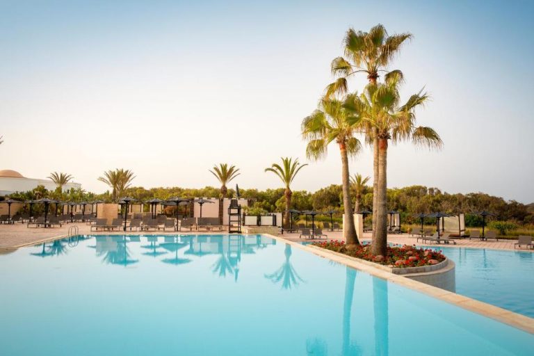 Piscina exterior con palmeras y tumbonas del Robinson Agadir All Inclusive en Marruecos