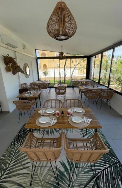 Restaurante con terraza acristalada y mobiliario de ratán del Hôtel L'Escale Coté Port