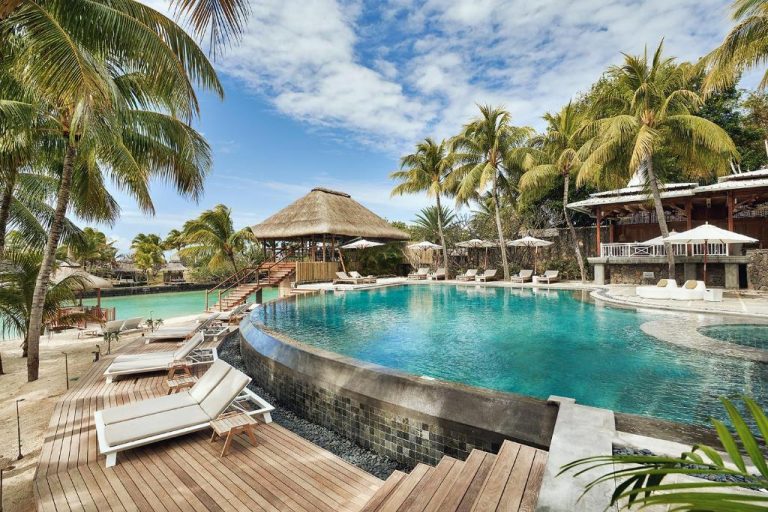 Piscina infinita rodeada de palmeras y tumbonas en Paradise Cove Boutique Hotel Adults Only Mauricio