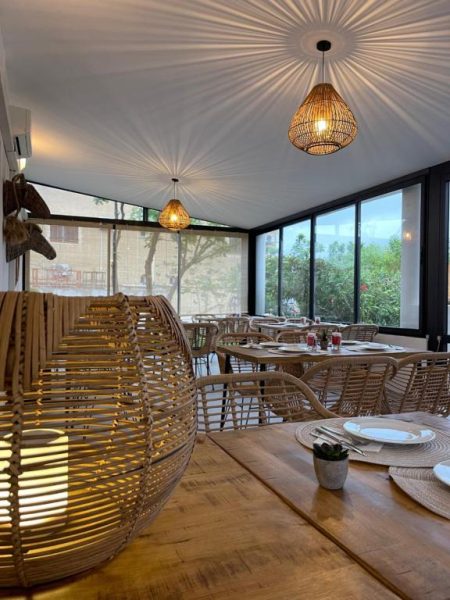 Restaurante interior con sillas de ratán y lámparas de mimbre del Hôtel L'Escale Côté Port