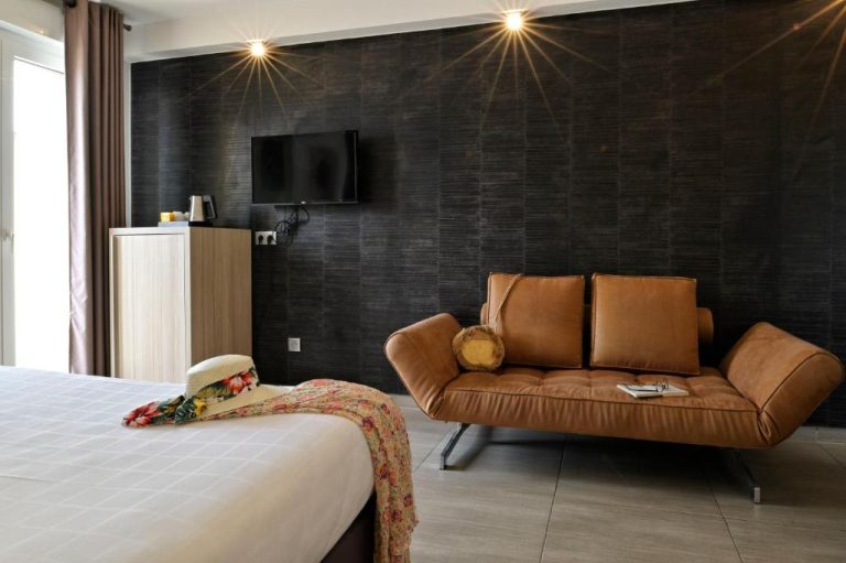 Habitación moderna con sofá de cuero marrón y pared negra en Hôtel L'Escale Coté Port
