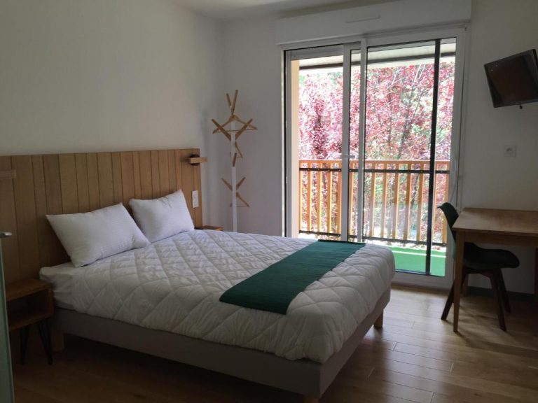 Habitación doble con balcón y vistas al jardín en Logis Hôtel Les Tilleuls