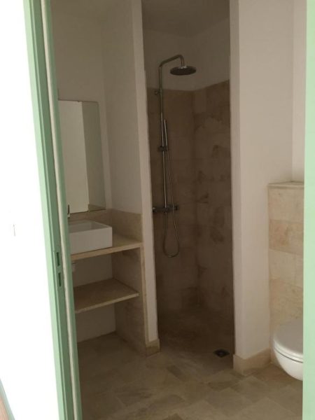 Baño moderno con ducha de lluvia y lavabo empotrado en Logis Hôtel Les Tilleuls