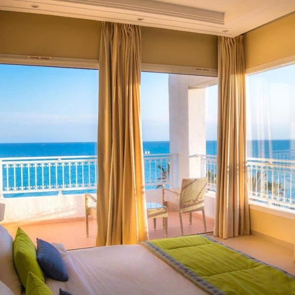 Habitación con cama doble y balcón con vistas al mar mediterráneo en Hotel Bel Azur Thalasso & Bungalows