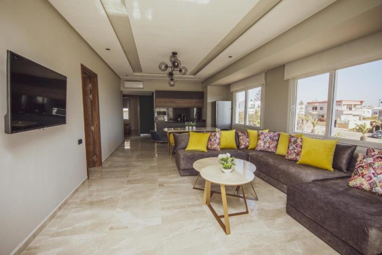 Amplio salón moderno con sofá gris y cojines amarillos en el Ocean Atlantic View Hotel