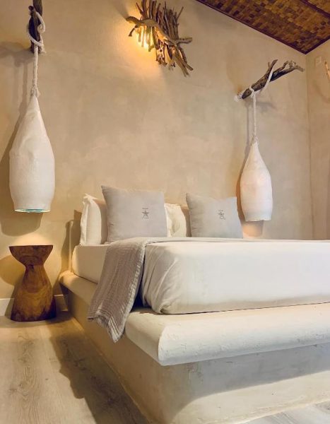 Habitación de lujo con cama doble y decoración natural en Thari Fushi Luxury Maldives Resort