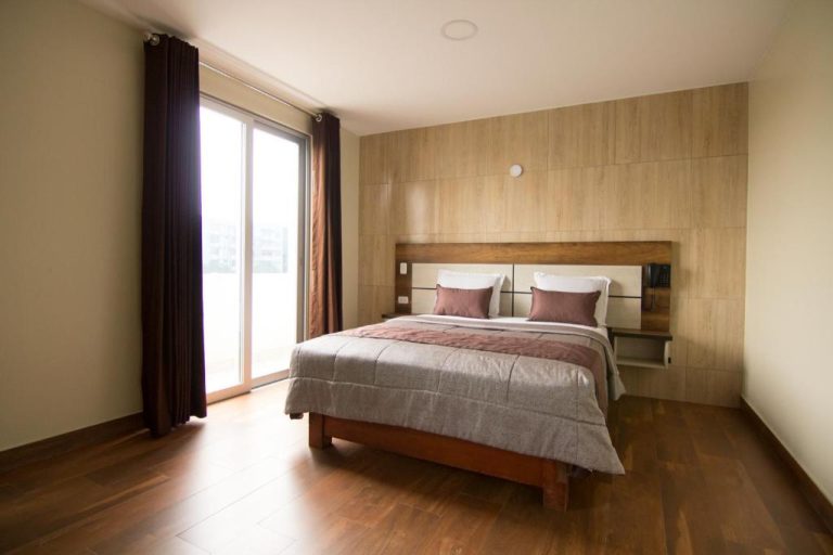 Habitación doble con cama matrimonial y suelo de madera en Hotel Martinika