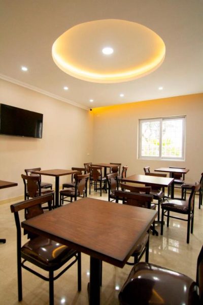 Comedor interior del Hotel Martinika con mesas de madera, sillas tapizadas y techo decorativo iluminado