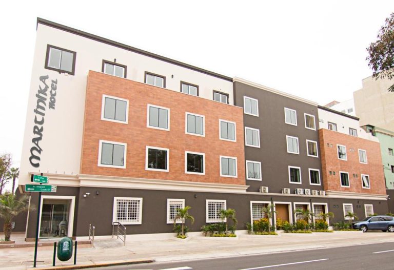 Fachada exterior del Hotel Martinika con acabados modernos en ladrillo y detalle de señalización urbana
