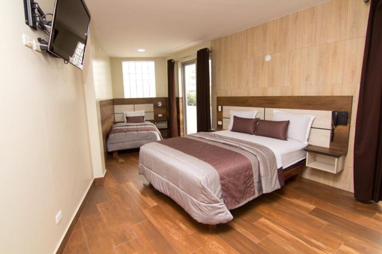 Habitación doble con dos camas y suelo de madera del Hotel Martinika con TV de pared