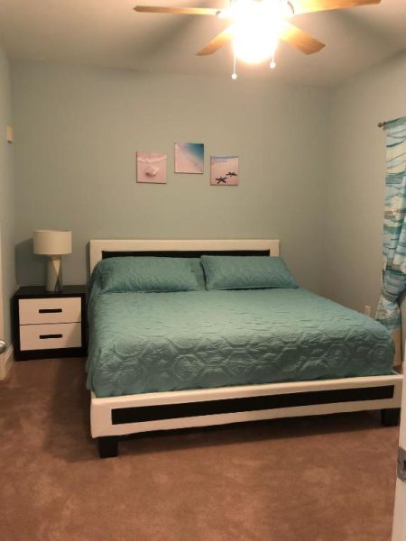 Habitación con cama doble y decoración costera en Laketown Wharf Resort, ideal para snowbirds