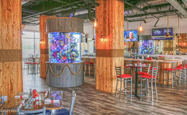 Bar y restaurante con acuario cilíndrico en Laketown Wharf Resort, decoración náutica de madera