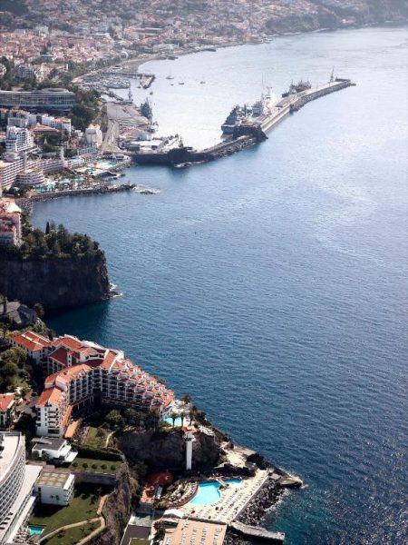 Vista aérea del hotel The Cliff Bay PortoBay en Funchal, Madeira, con piscinas y acantilado frente al mar