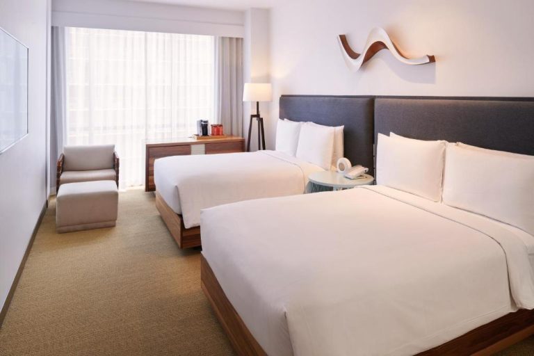 Habitación doble con dos camas queen y ventanal luminoso en Hyatt Centric Waikiki Beach