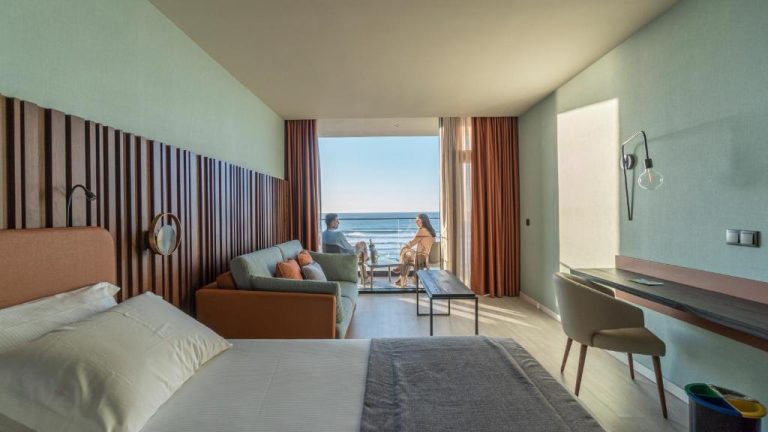 Habitación con sofá, escritorio y terraza con vistas al mar en Hotel Verde Mar & SPA