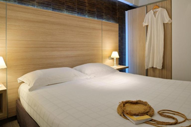 Habitación doble con cabecero de madera y decoración elegante en Hôtel L'Escale Coté Port