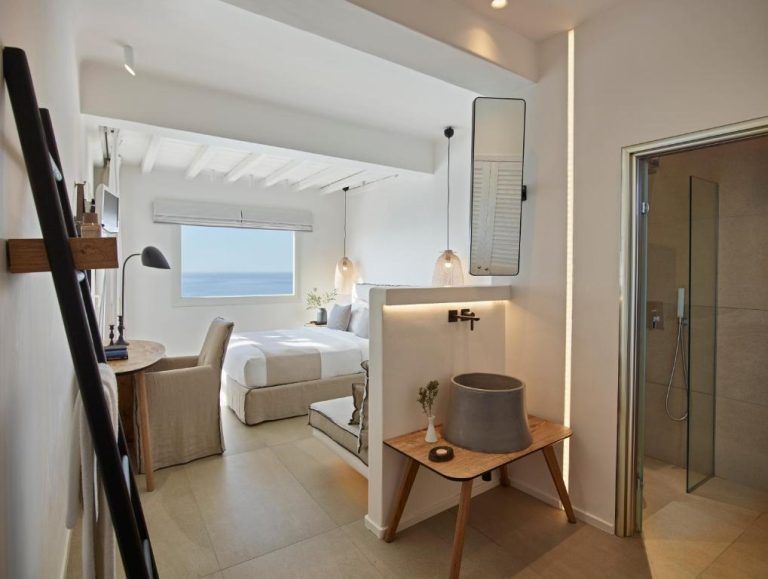 Habitación de lujo con cama doble, baño abierto y vistas al mar en Vencia Boutique Hotel