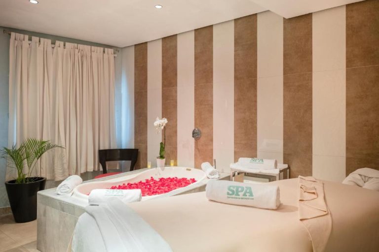 Suite spa romántica con bañera de pétalos de rosa y camillas de masaje en JOIA Rose Hall by Iberostar
