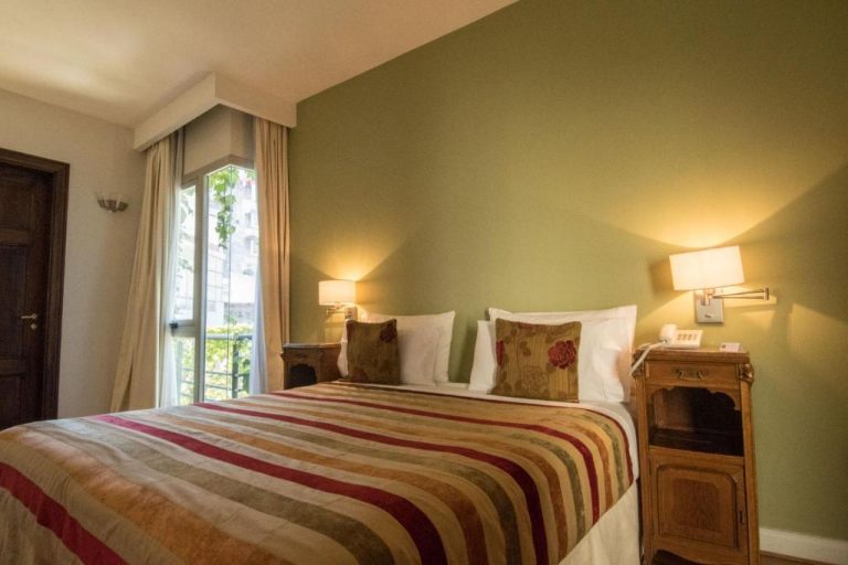 Habitación doble clásica con cama matrimonial y pared verde en Magnolia Hotel Boutique