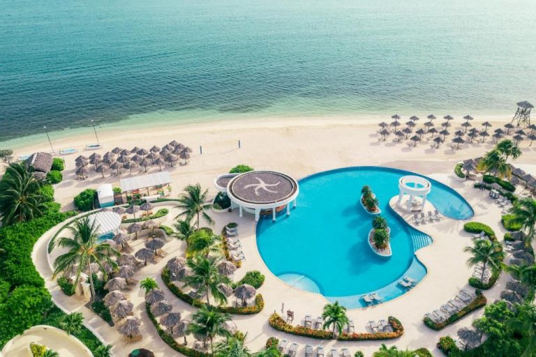 Vista aérea de la piscina exterior y playa del Iberostar Selection Rose Hall Suites All Inclusive en Jamaica