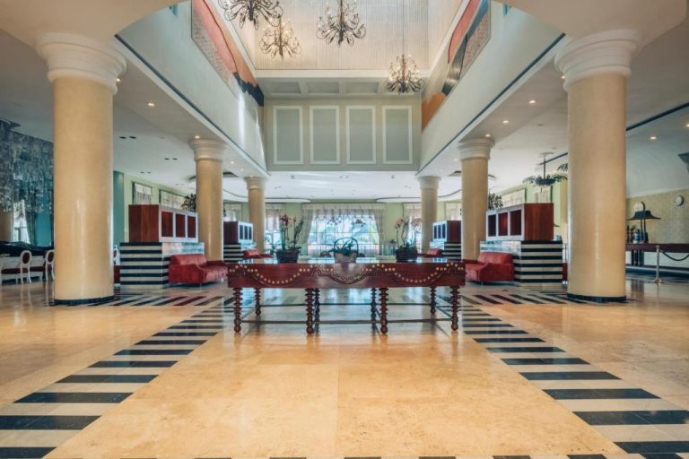 Lujoso lobby con columnas mármol y chandeliers del Iberostar Selection Rose Hall Suites All Inclusive