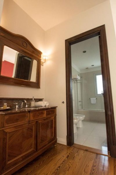 Baño clásico con mueble de madera y mármol en el Magnolia Hotel Boutique