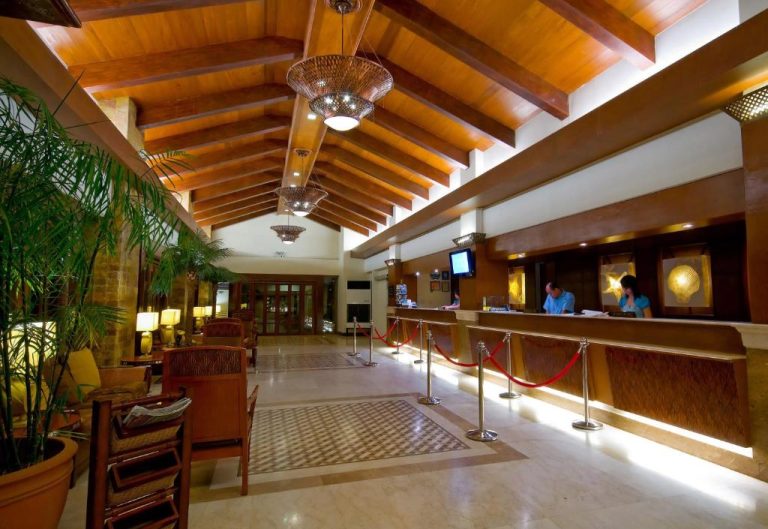 Recepción principal con techo de madera y mostrador de check-in del Henann Regency Resort and Spa