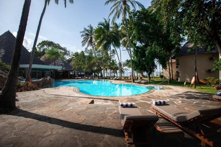 Piscina exterior con tumbonas y palmeras tropicales del Severin Sea Lodge frente al mar