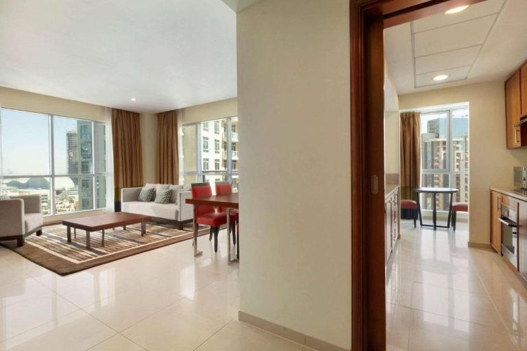 Salón y cocina con vistas a la ciudad en el Ramada by Wyndham Downtown Dubai