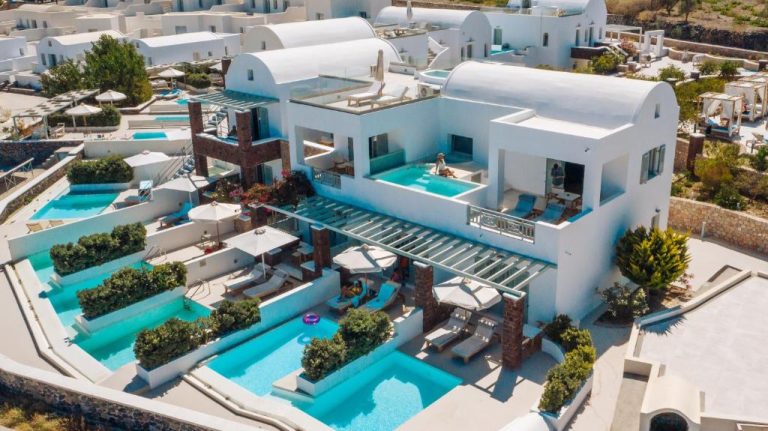 Vista aérea de las piscinas exteriores y terrazas del Astro Palace Hotel & Suites en Santorini