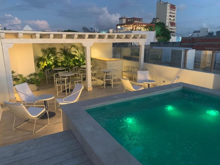 Piscina iluminada en la terraza rooftop del B Haus Hotel Boutique con zona lounge y bar