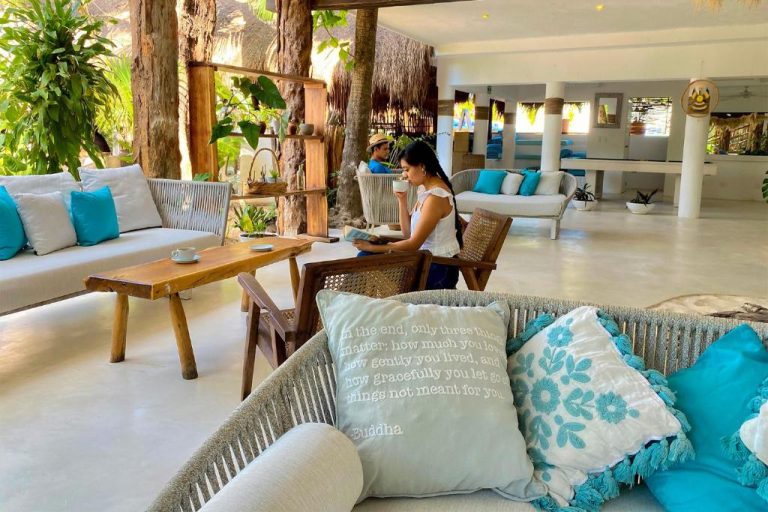 Zona de descanso con sofás y cojines en el lobby del Cabanas Tulum Beach Hotel & Spa en México