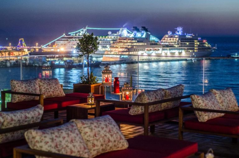 Terraza lounge del Ilayda Avantgarde Hotel con vistas nocturnas al puerto y cruceros iluminados