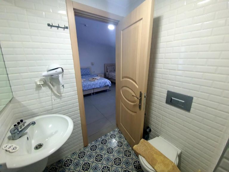 Baño completo con lavabo y secador de pelo en Ressa Apart, con vista al dormitorio