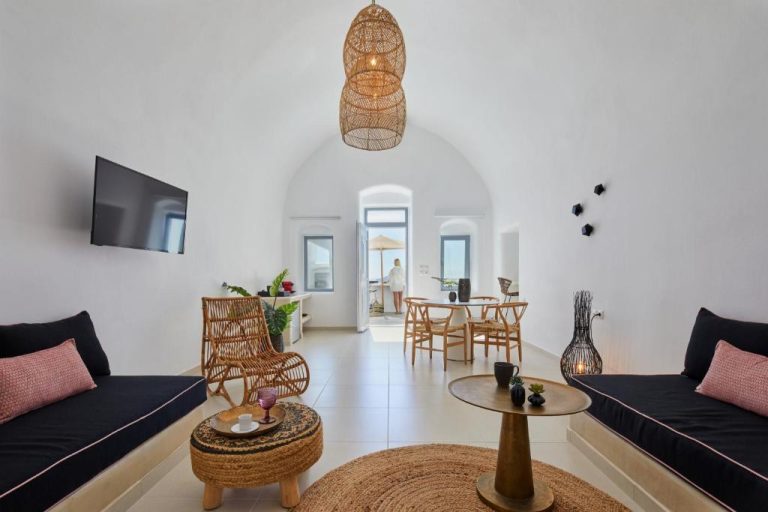 Salón con bóveda blanca y decoración natural en U & Me Suites Santorini con vistas al exterior
