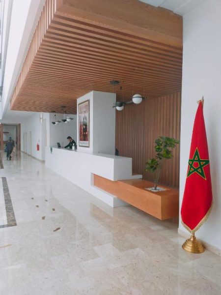 Recepción y lobby principal del Hotel Zephyr Agadir con bandera de Marruecos y diseño moderno