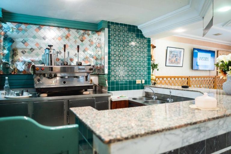Bar cafetería con máquina de espresso profesional Conti y azulejos verdes en Hôtel Résidence Monia